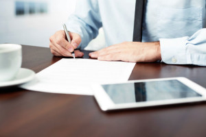 man signing contract disposition of surplus property