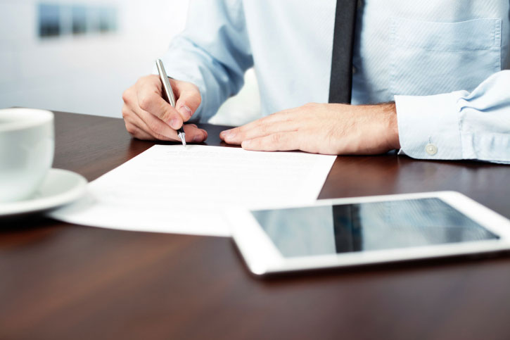 man signing contract disposition of surplus property