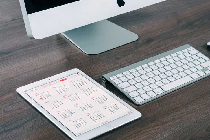 record keeping search services tablet with computer on desk calendar